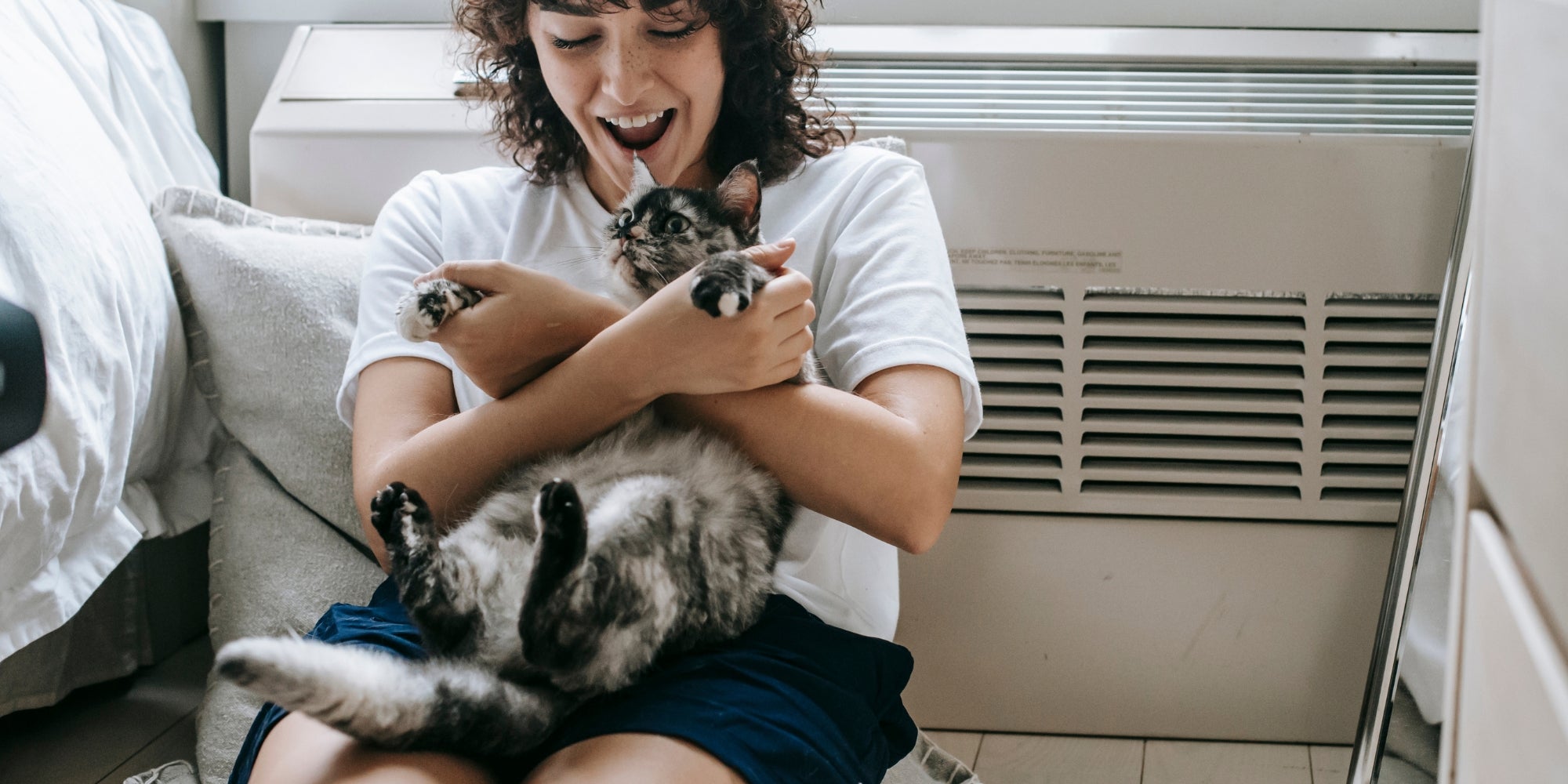 Mujer alegre jugando con gato