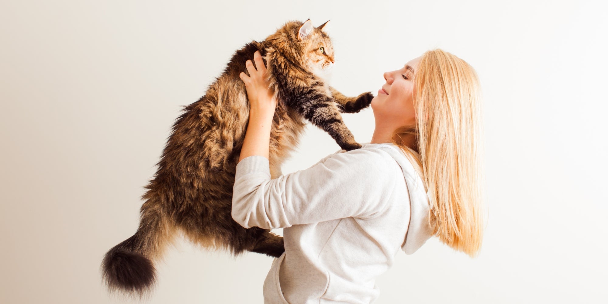 Mujer feliz jugando con su nuevo gato adoptado