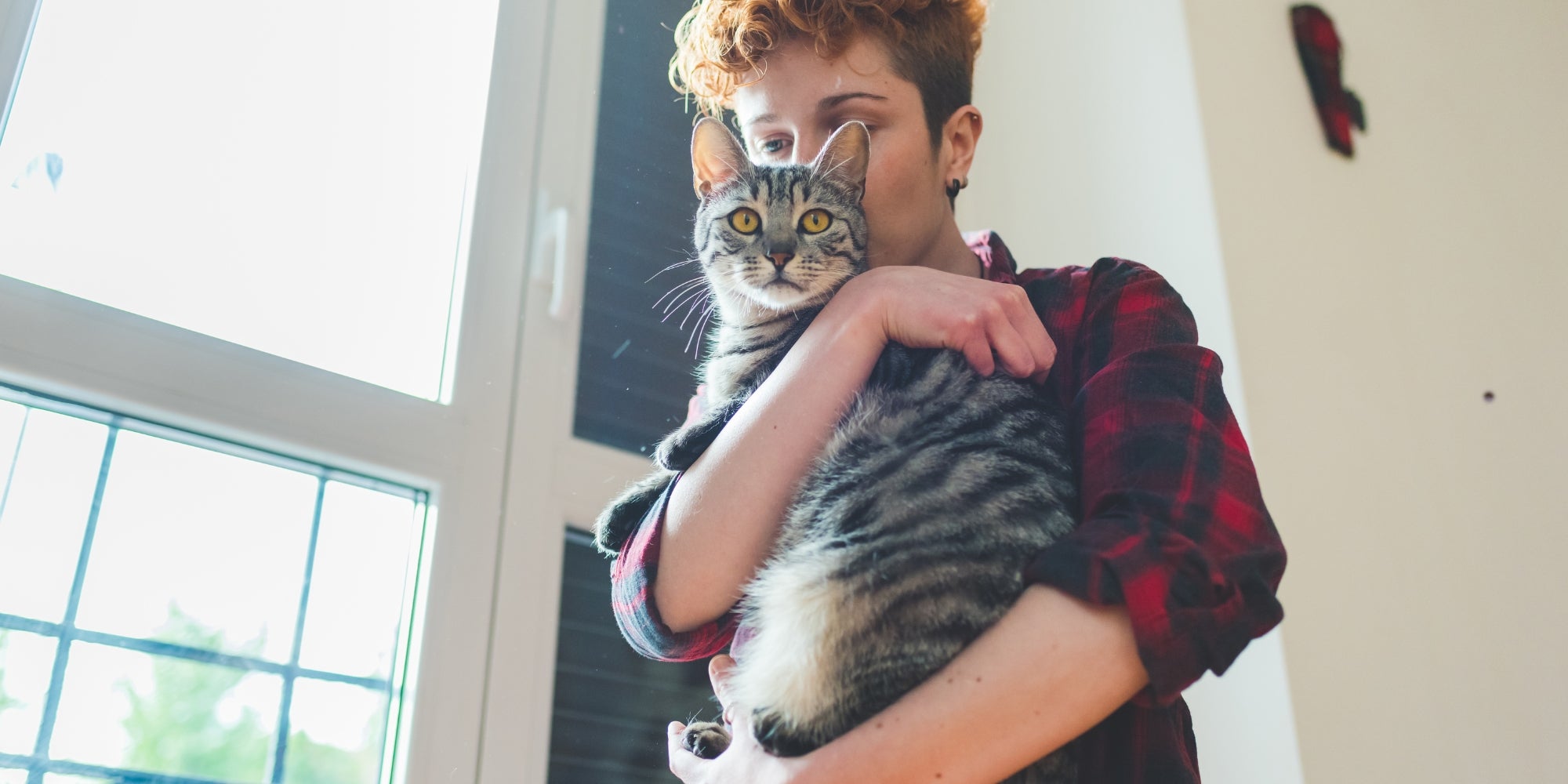 Mujer abrazando a su gato