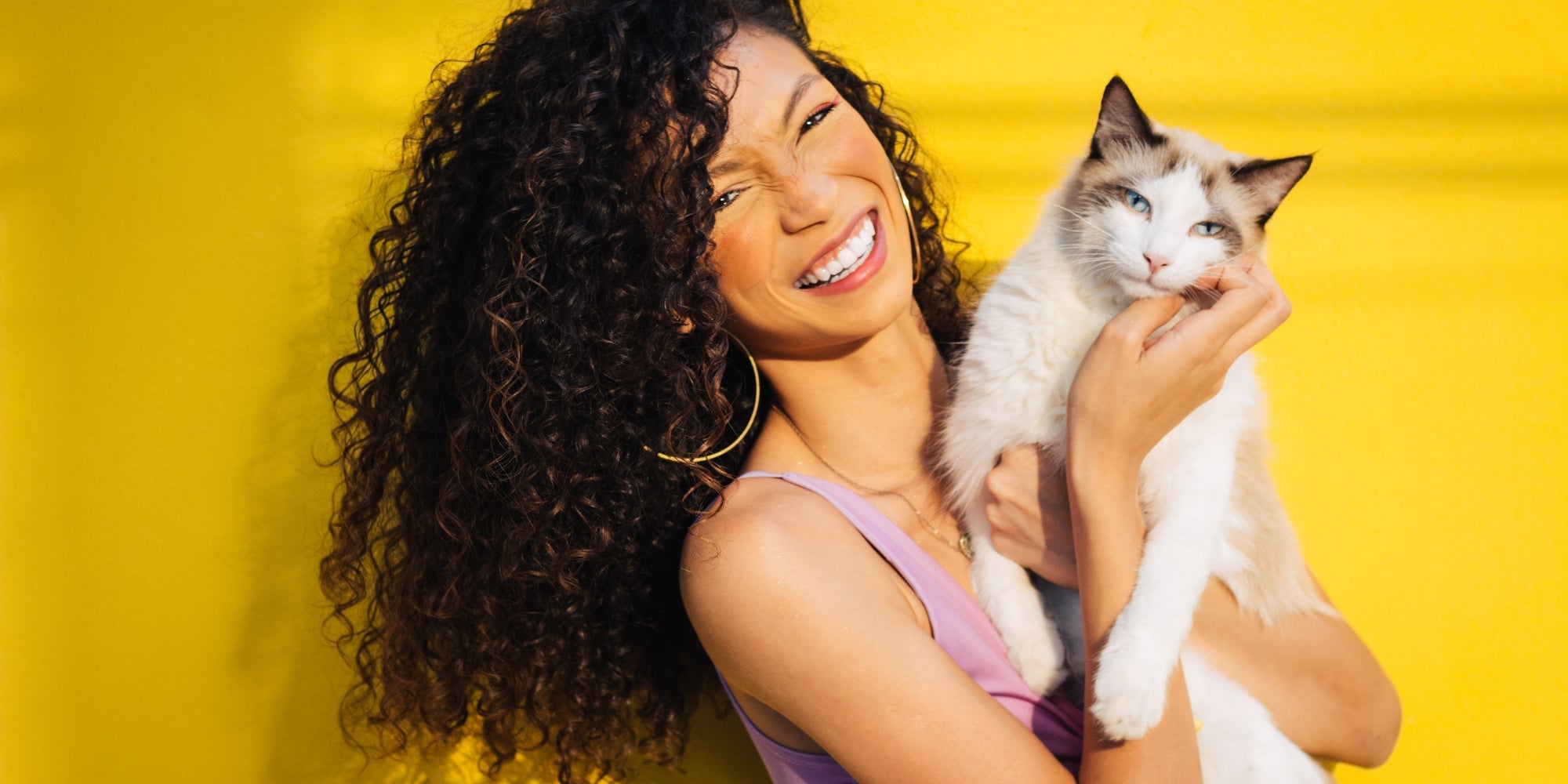 Mujer sonriente con un gato en brazos
