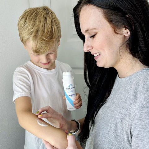 Mom applying eczema cream for kids on son's arm