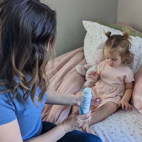 Mother applying Arctiva Eczema Cream to her child