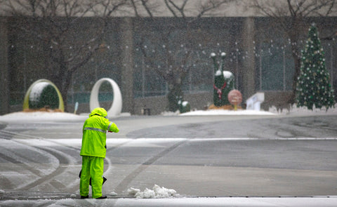 man sweeping on snowy day