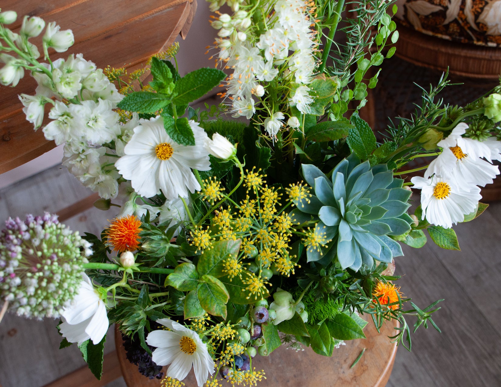 Lush, green, Mediterranean-inspired Flower arrangements created by WildFlora in Los Angeles using Cosmos, Lisianthus, Foxtail Lily, Amaranthus, Allium, Queen Anne's Lace, Delphinium, and Centaurea, grapes, artichoke, mint, rosemary, kale, cabbage, & berries.