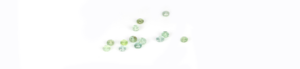 montana sapphire beads in green and teal color on a cream background