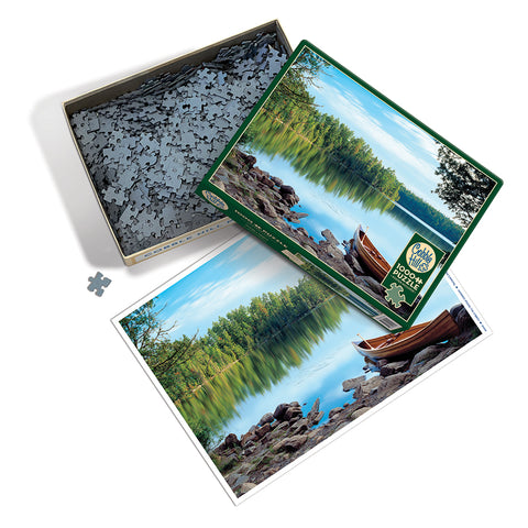 Layout of Natures Mirror puzzle with puzzle pieces, poster, and box lid of scenic lake and blue sky