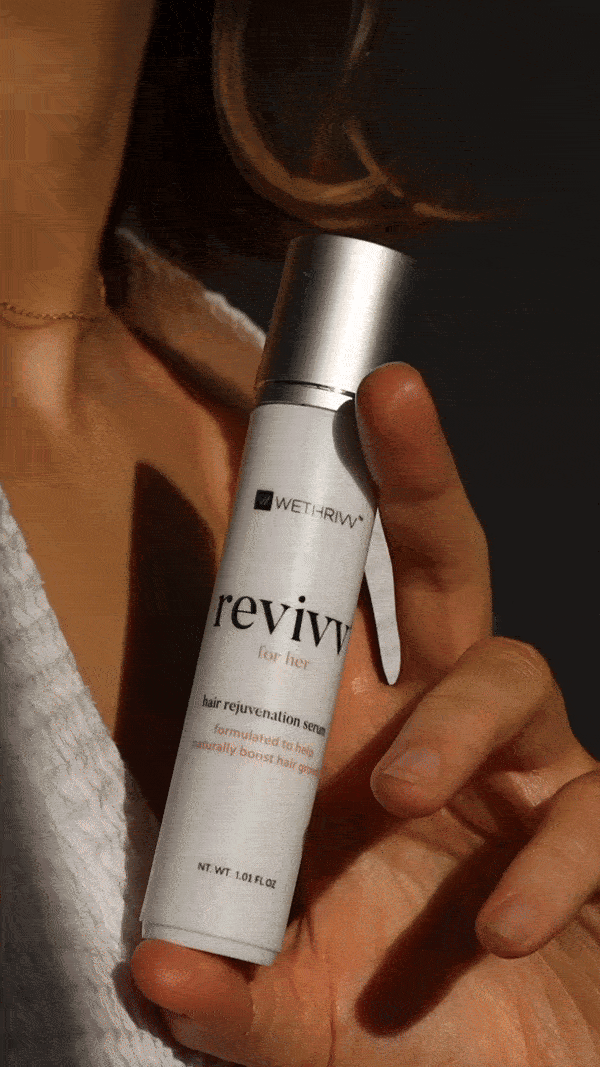 Person holding Revivv hair rejuvenation serum for women in their hand.