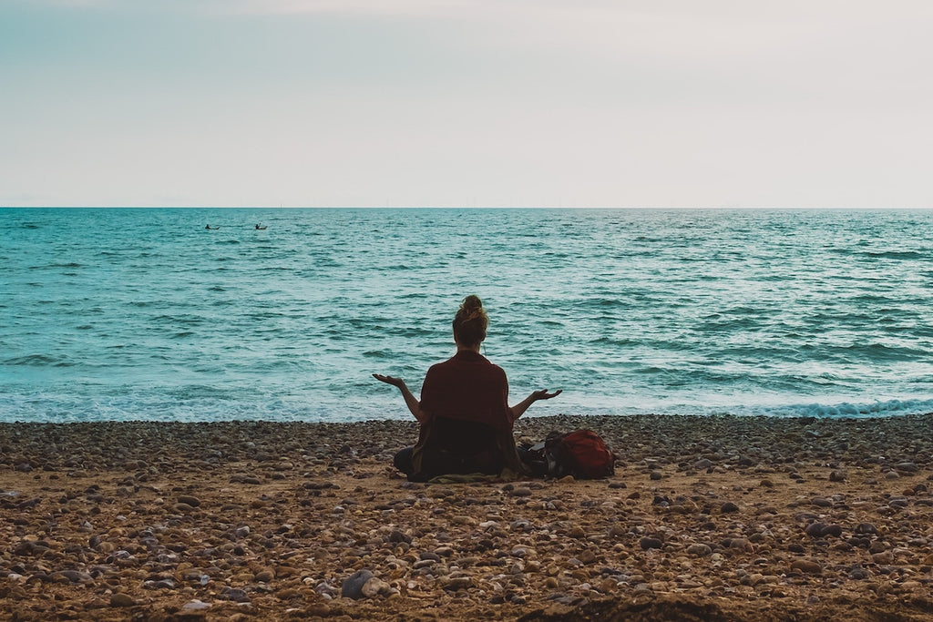 woman meditating on beach