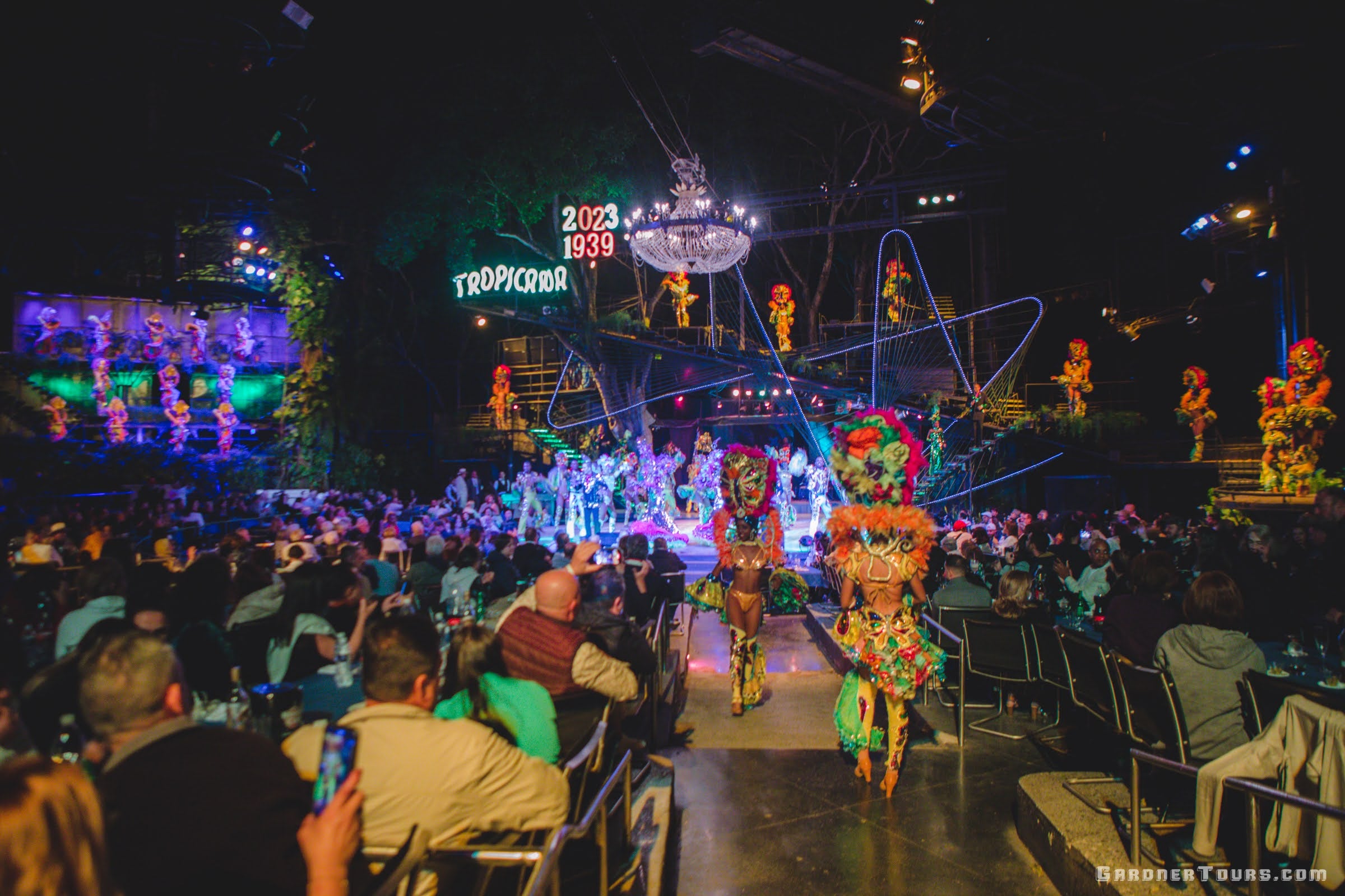 A wide view of the entire stage, all colorful performers, and some closeup performers in full regalia at the Tropicana Cabaret's Big Show in Havana, Cuba in 2023