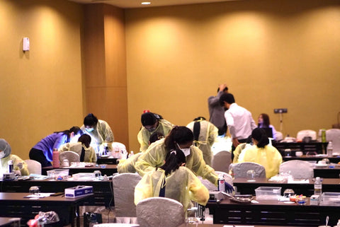 A room that has dental students sitting on seats and practicing dental procedures while dental teachers are giving them guidance on how to properly use dental burs sold by mr bur the best international dental bur supplier in the world