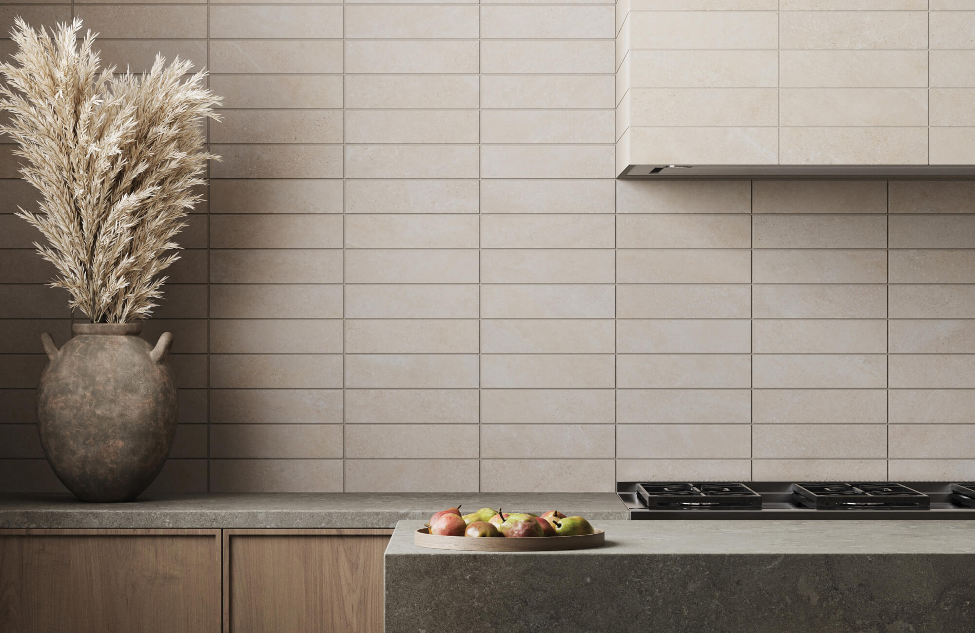 Minimalist kitchen with matte beige subway tile backsplash and concrete countertops, accented by a rustic vase of dried wheat and a plate of fresh fruit