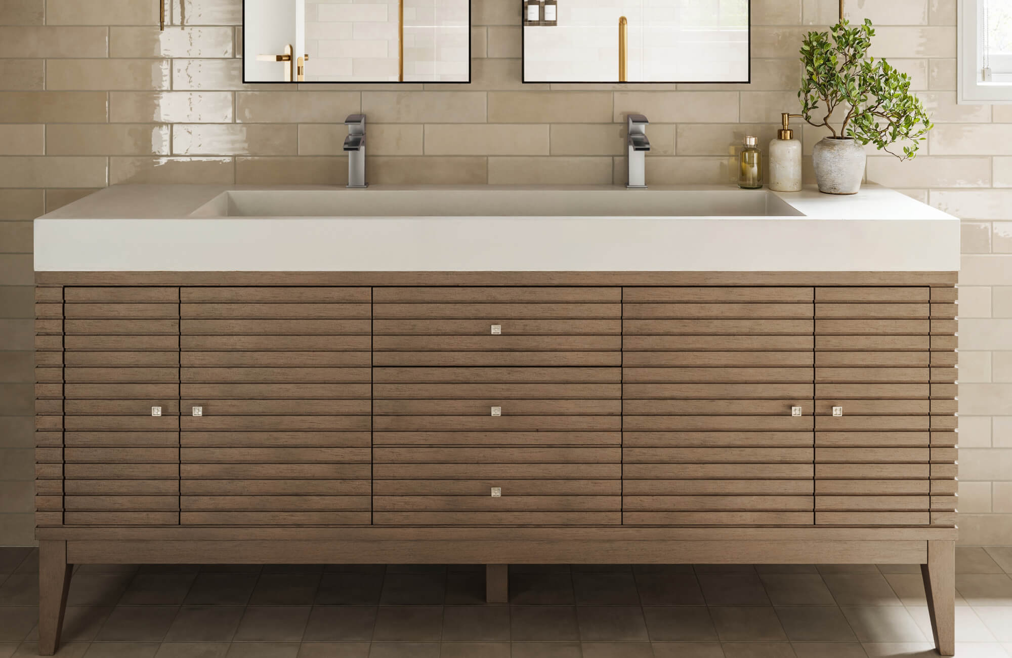 Wide double-sink vanity with horizontal slatted wood design and sleek square pulls, set against glossy beige subway tiles.