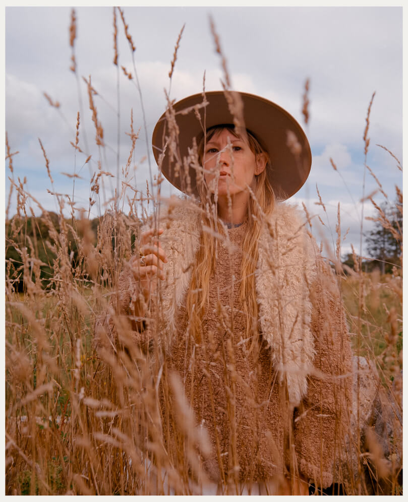 kate in a wide brim hat in a field