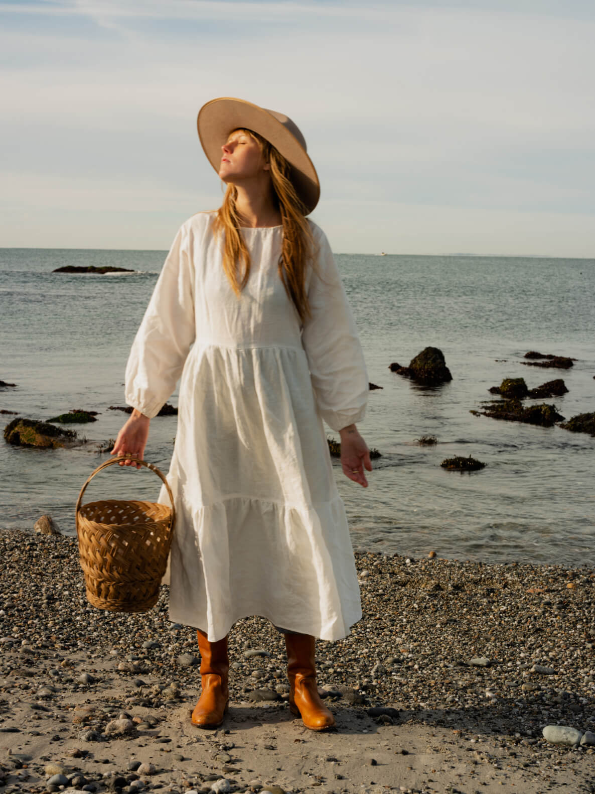 kate on the beach wearing a flowy white dress