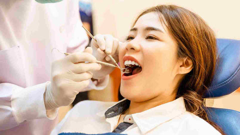 A dentist checking woman's teeth