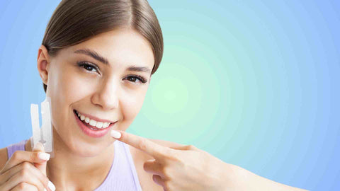 A lady holding whitening strips