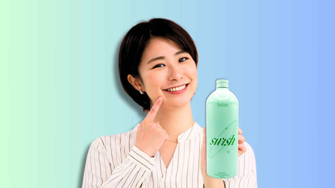 A woman showing alcohol free mouthwash