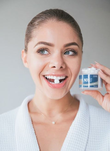 A lady holding NOBS Toothpaste