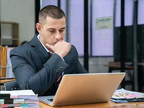 Businessman looking at a laptop for potential IT scams in Miami
