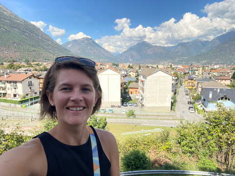 Standing in front of a view of the city and mountains in Domodossola, Italy