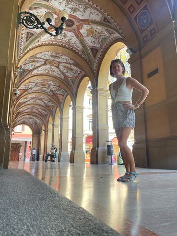 Standing under an ornate portico in Bologna, Italy