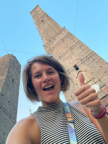 Celebrating the completion of climbing to the top of Asinelli Tower in Bologna, Italy