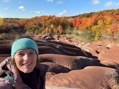 Overlooking the Cheltenham Badlands in Canada during Autumn with bright colored leaves in the background