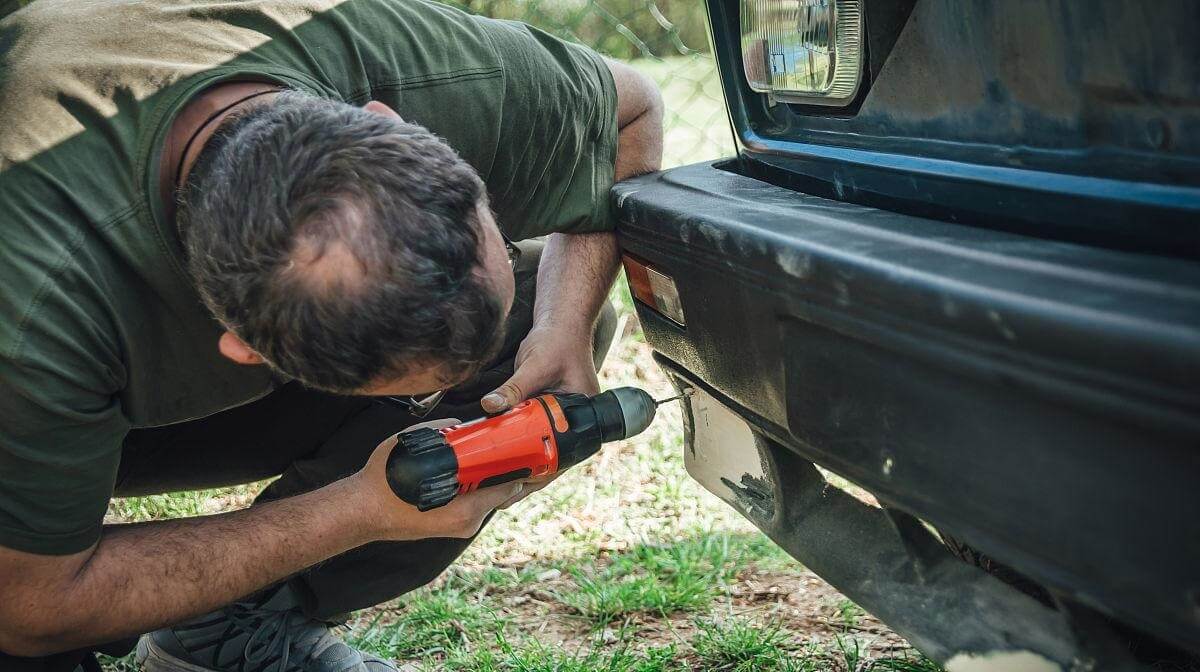 A mechanic is fixing bumper damage