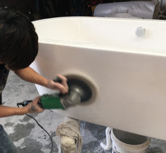 Sanding the bathtub surface with a sander