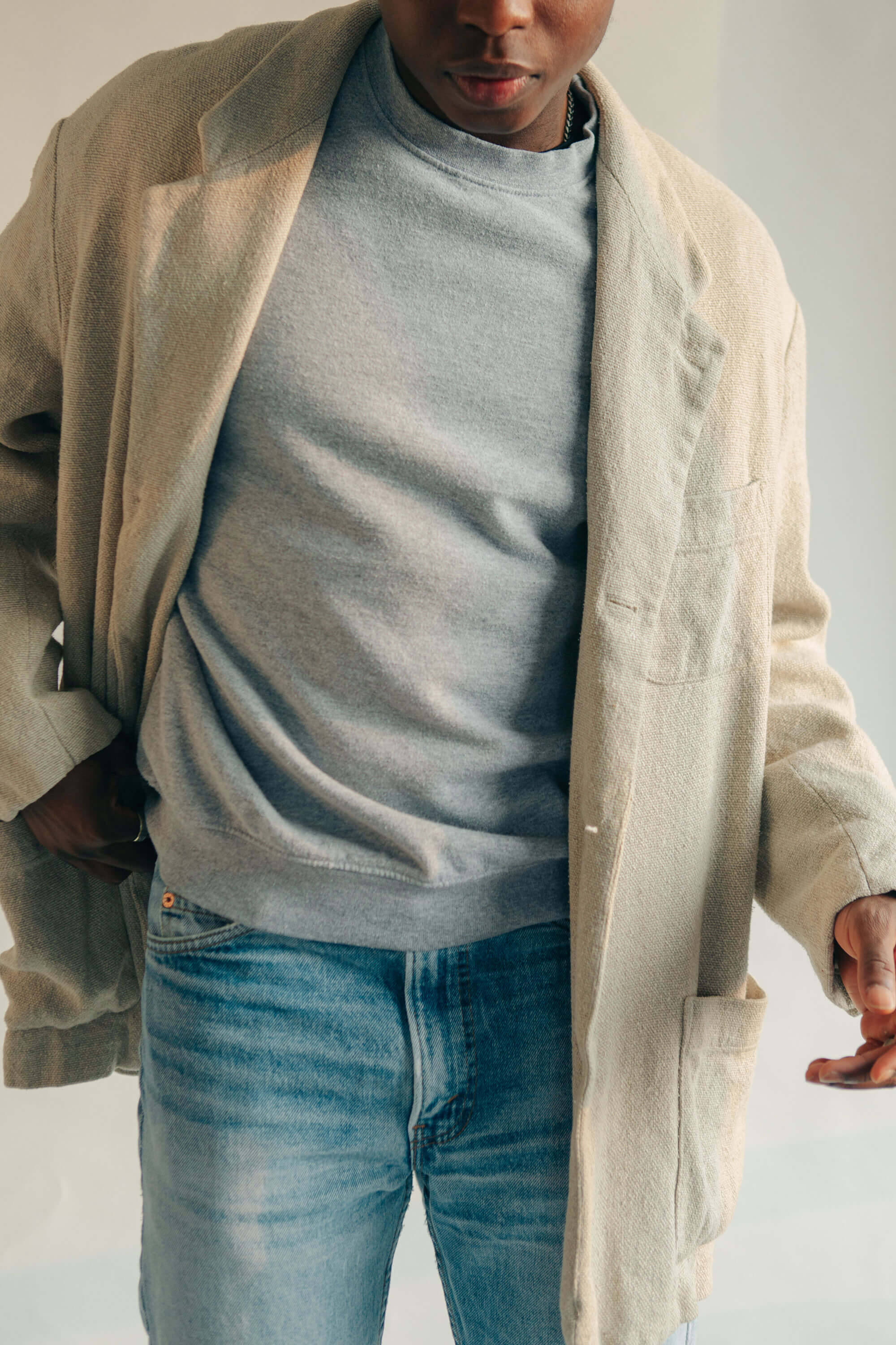 Man in gray sweater and tan coat