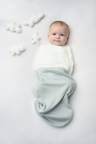 baby boy wrapped in blue baby swaddle from mori