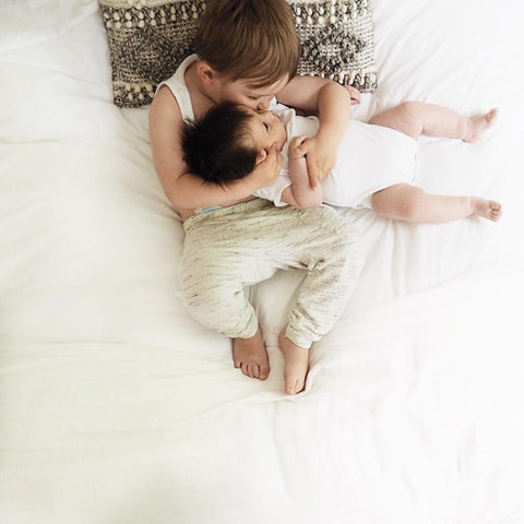 big brother and little brother hugging and kissing on bed