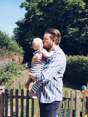 dad and child in garden kissing
