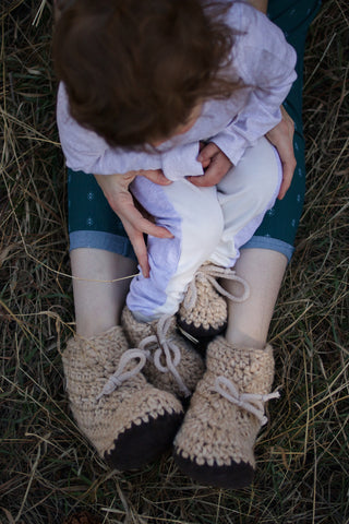 baby and mother in home knitted boots