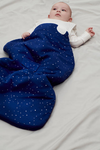 baby lying down wearing a sleeping bag