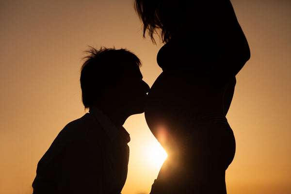 man kissing pregnant stomach