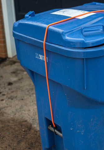 bungee cord keeping trash can closed