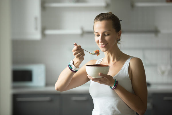 Image of woman eating fruit salad as a healthy snack after training