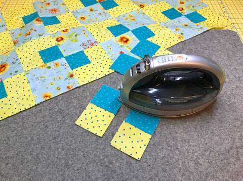 Wool Pressing Mat displayed with an iron and quilt block piecing