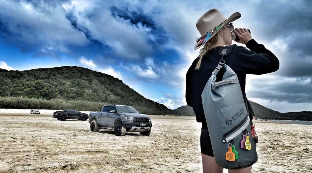 LADY ON THE BEACH HOLDING A NORTH STORM WATERPROOF DRY BAG