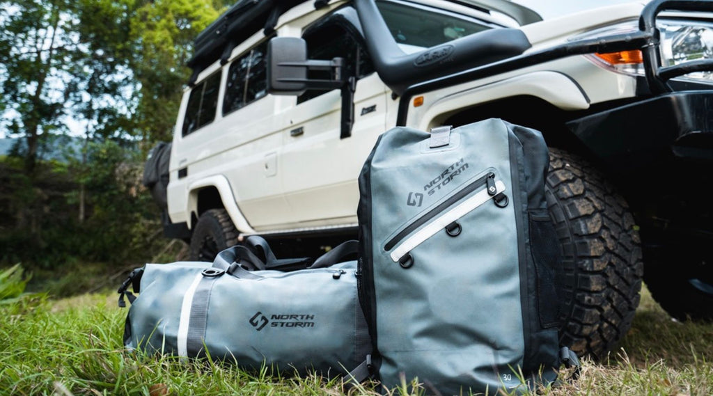 A NORTH STORM DUFFEL AND BACKPACK ON THE GRASS.