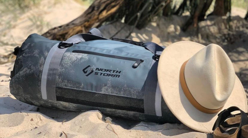 NORTH STORM WATERPROOF DUFFEL BAG ON THE BEACH.