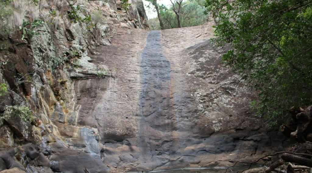 A VERY DRIED UP WATERFALL FROM DROUGHT. JUST A ROCK FACE NOW WITH WATERMARKS FROM THE OLD WATERFALL.
