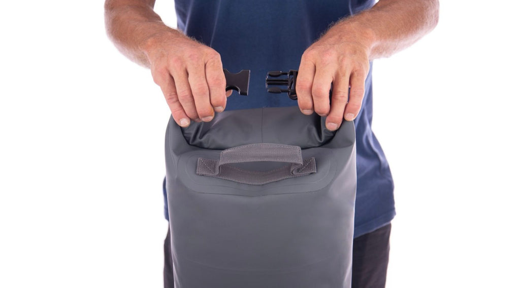 A MAN CLIPPING UP A NORTH STORM WATERPROOF DRY BAG.