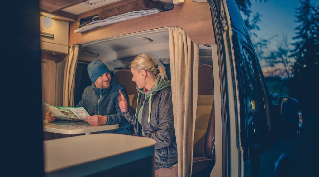 A couple looking at a map in a campervan.