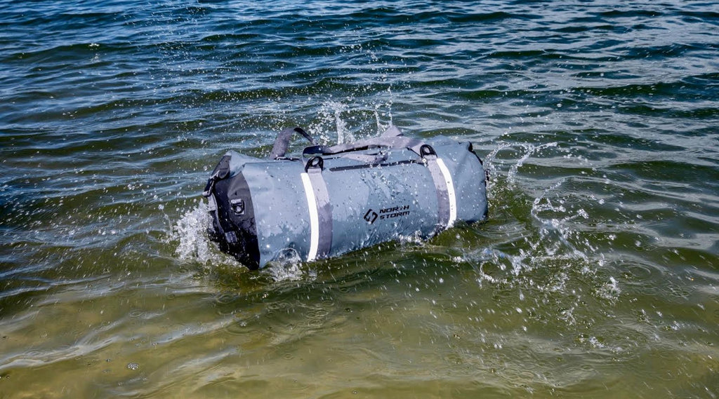 A NORTH STORM 60 LITRE DUFFEL BAG MAKING A SPLASH IN THE WATER AND FLOATING.