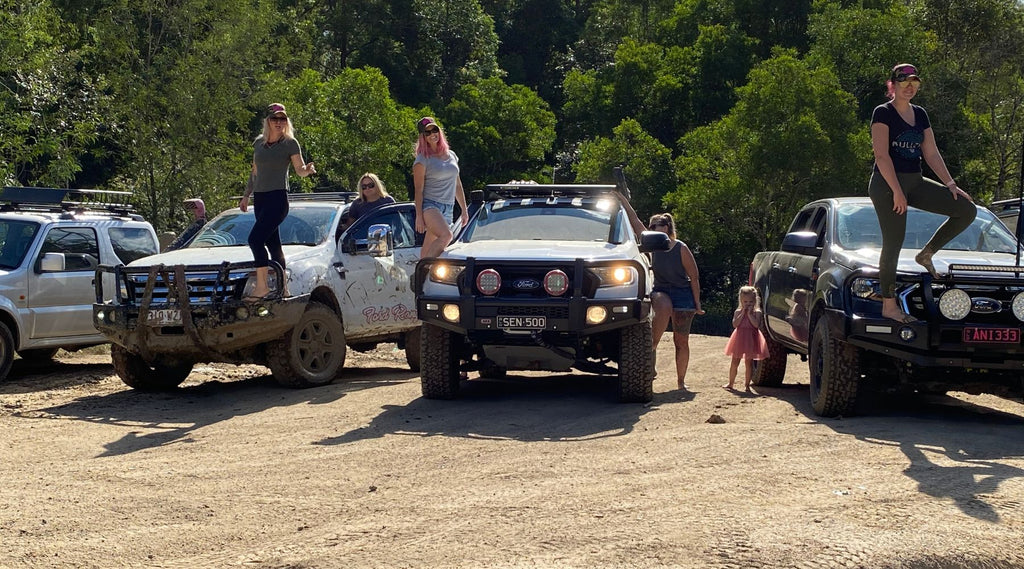 A GROUP OF LADIES AND THIER FOUR WHEEL DRIVES IN THE BUSH.