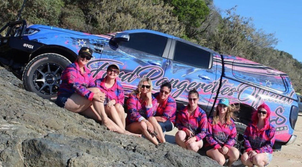 7 OF THE MEMBERS OF FORD RANGERETTES OFFICAL SITTING ON A ROCK IN FRONT OF A 4X4.