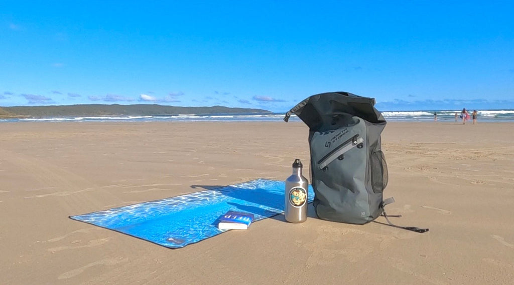 NORTH STORM BACKPACK AND TOWEL ON A BEACH