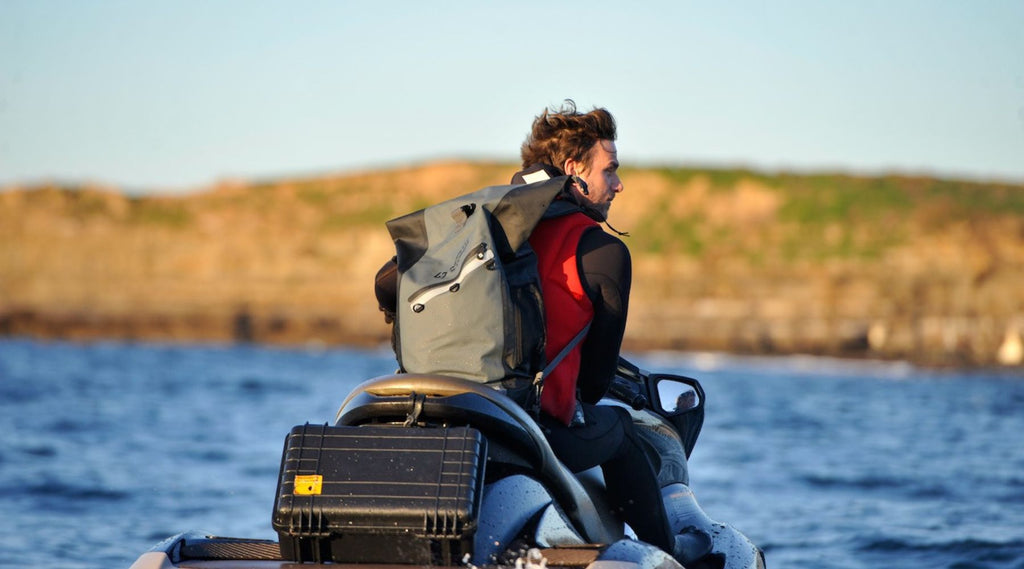 LANCE SITTING ON A JETSKI WEARING HIS NORTH STORM 30 LITRE WATERPROOF BACKPACK.